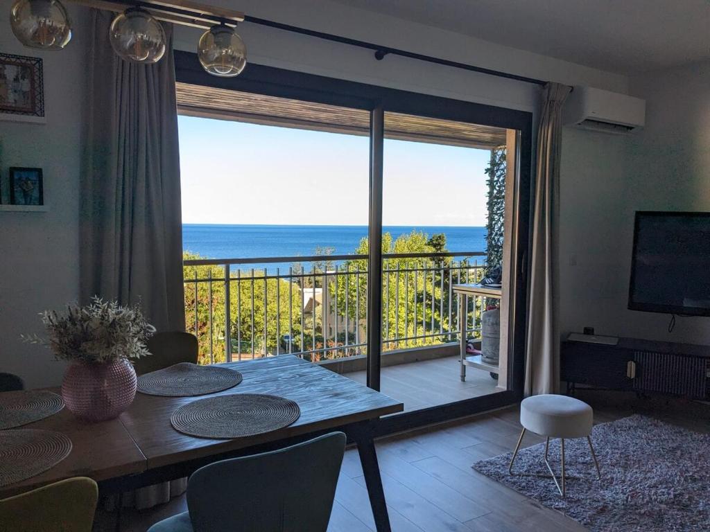 a living room with a table and a view of the ocean at U Flenu sea view in San-Martino-di-Lota