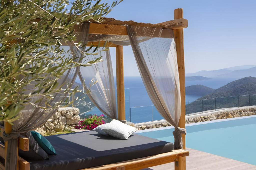 a bed on a balcony with a view of the ocean at Modern Country Villa in Lefkada