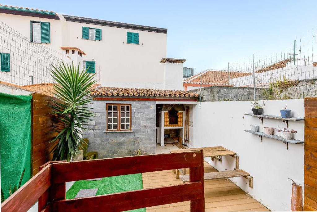 a balcony of a white building with a wooden bench at Vista Das Estrelas M4 - Terceira in Praia da Vitória