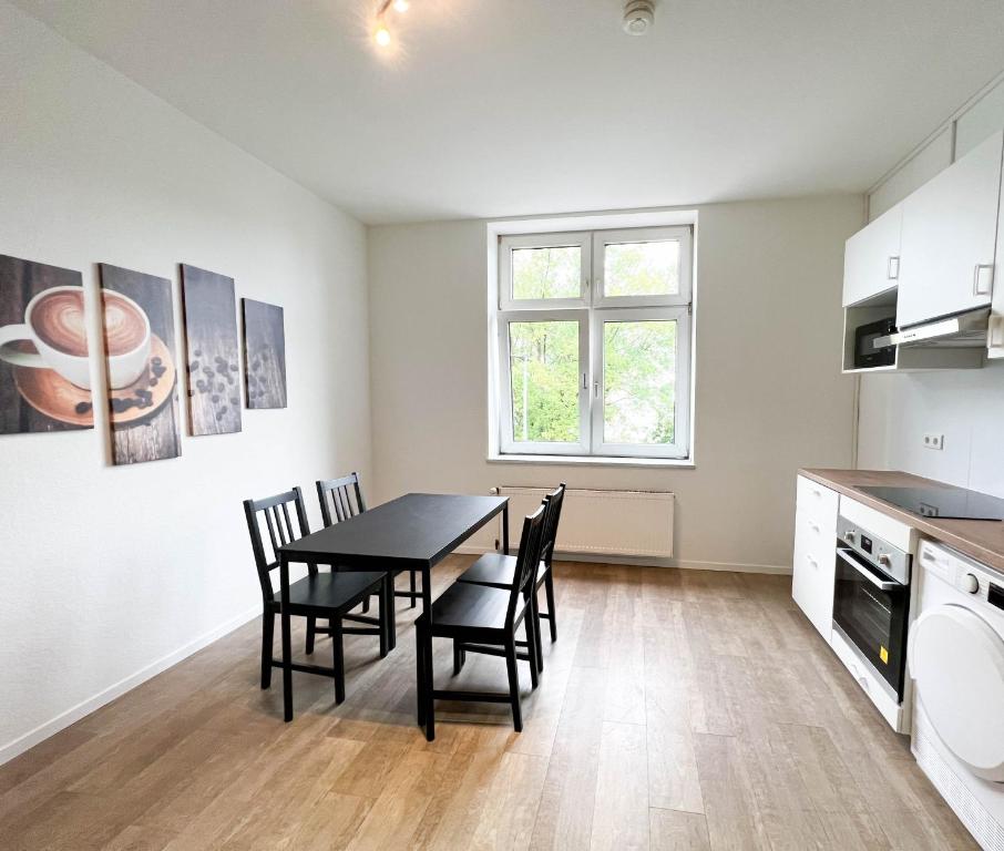 a kitchen with a dining room table and chairs at Key2Komfort in Duisburg