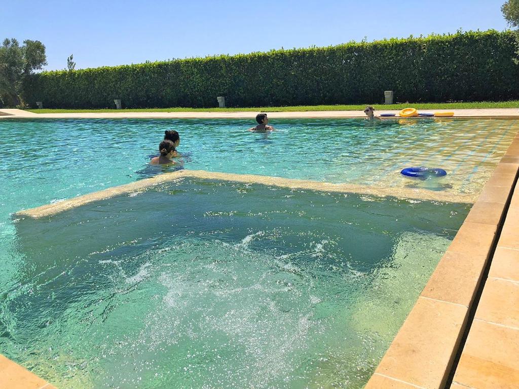 a group of people swimming in a swimming pool at Bungalow Italia in Otranto