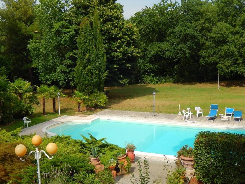 a swimming pool in a yard with chairs and trees at Villa Vittorio a 4km dal mare in Trebbiantico