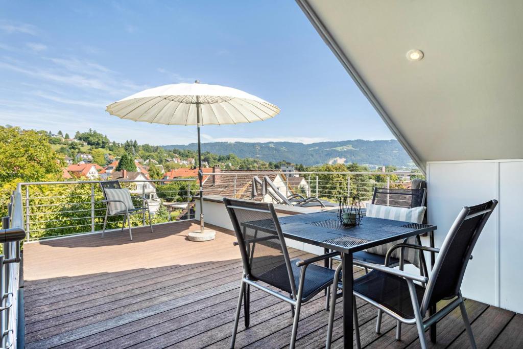 a balcony with a table and chairs and an umbrella at Pfänderblick in Lindau