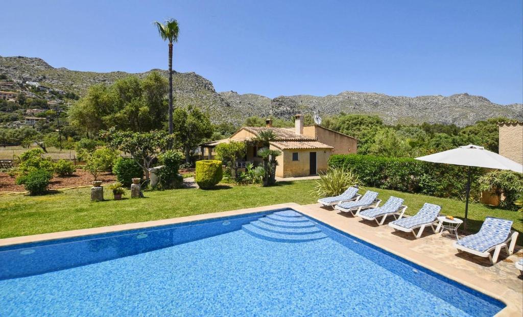 a swimming pool with chairs and a house at Tonina in Pollença