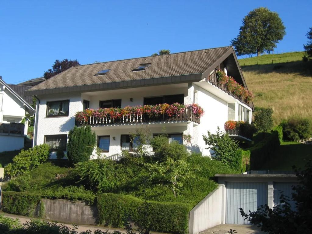 a white house with flowers on the balcony at Haus Huber in Wolfach