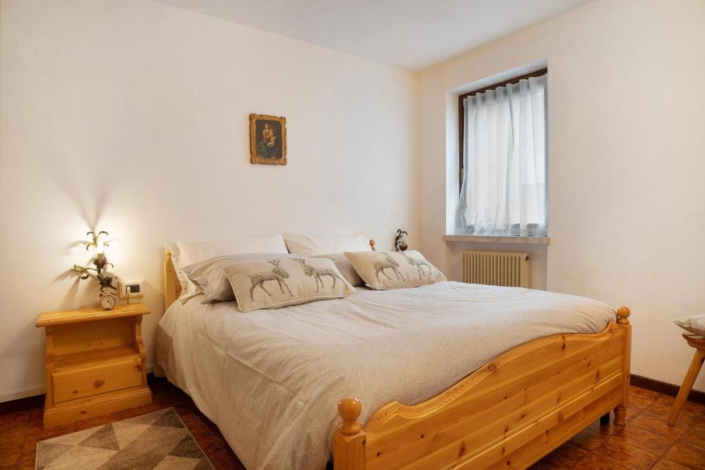 a bedroom with a large bed and a window at Appartamento Eva in Folgaria