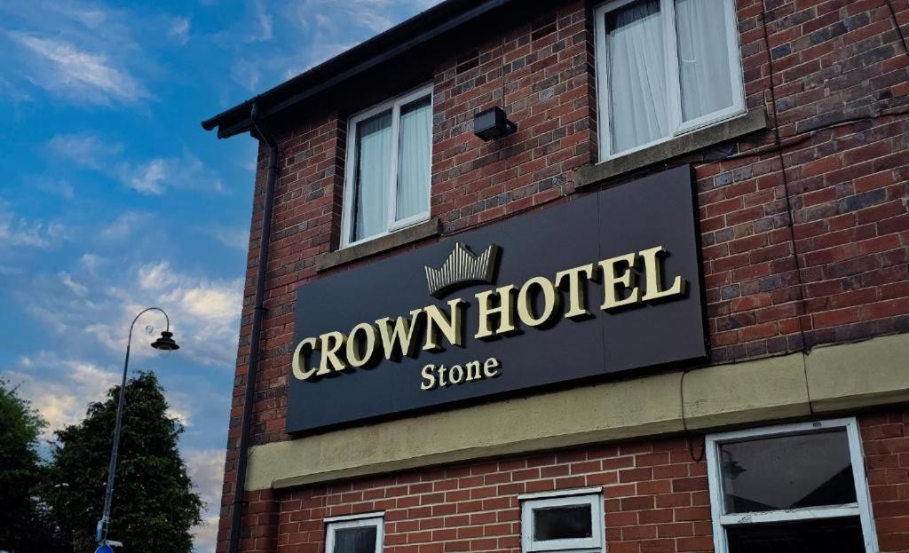 a sign for a crown hotel on the side of a brick building at The Crown Hotel in Stone