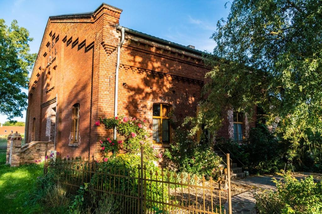 an old brick building with a fence in front of it at Ferienwohnung Sophienhof in Loitz
