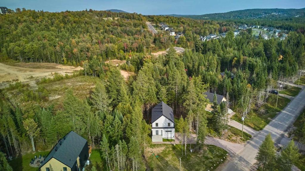 an aerial view of a house on a hill with trees at Villa Boreale - Private Spa Pool & Foosball in Valcartier Station