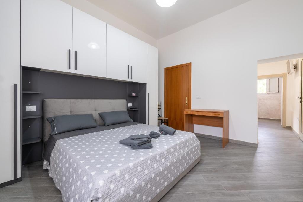 a bedroom with a large bed and a desk at Casa Claudia in Assemini