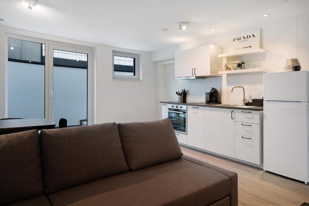 a living room with a couch and a kitchen at Schönes Apartment am Kaiserstuhl in Bahlingen