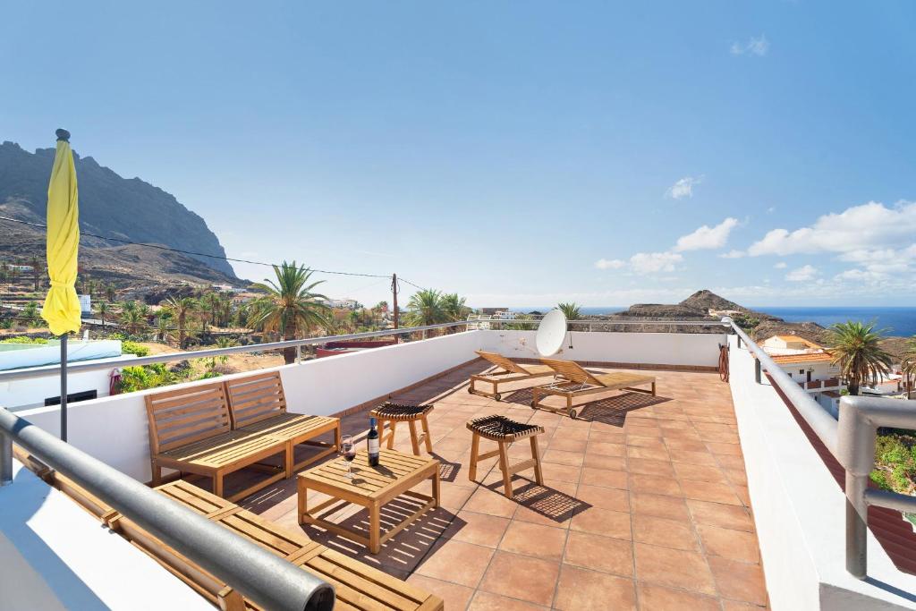 a balcony with tables and chairs and the ocean at Vivienda vacacional La Era Il in Vallehermoso