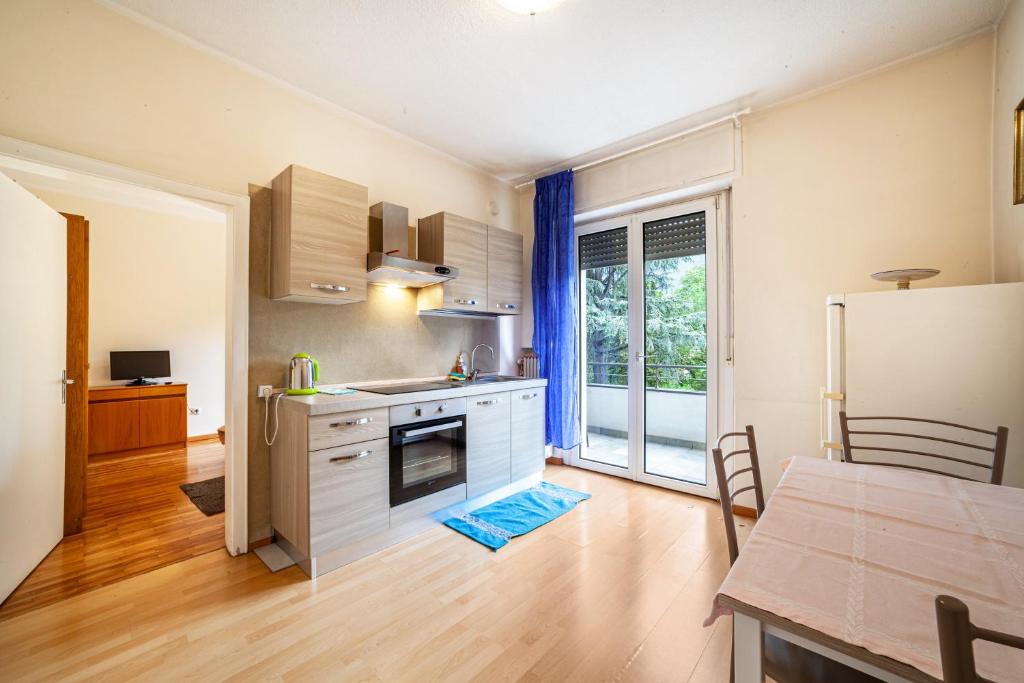 a kitchen with white cabinets and a table and a refrigerator at Residence Hubertus Ap 1 - Meran in Merano
