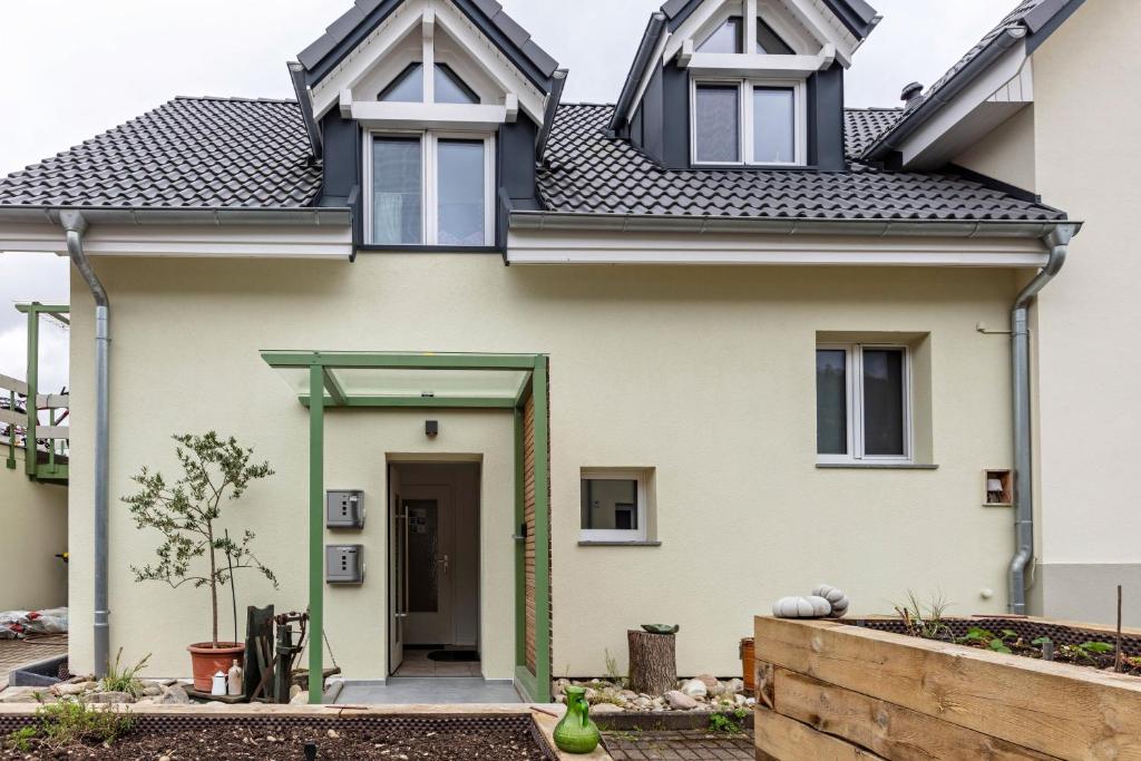 a white house with a green door at Kleine Auszeit in Rheinfelden