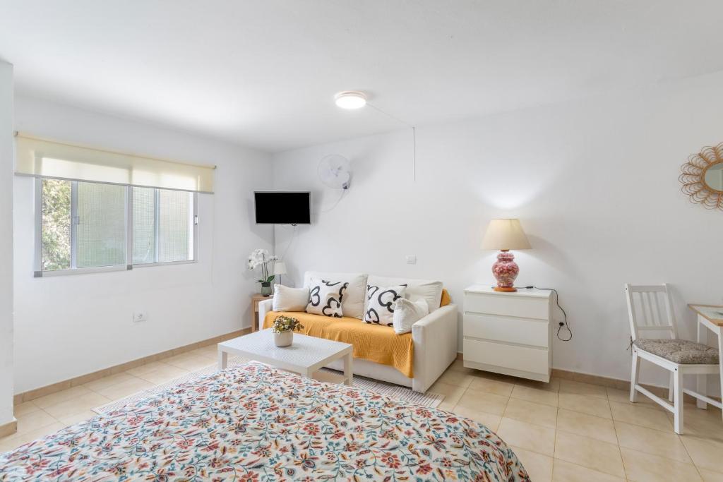a white bedroom with a bed and a couch at Apartamento Danoe 4 in Mogán