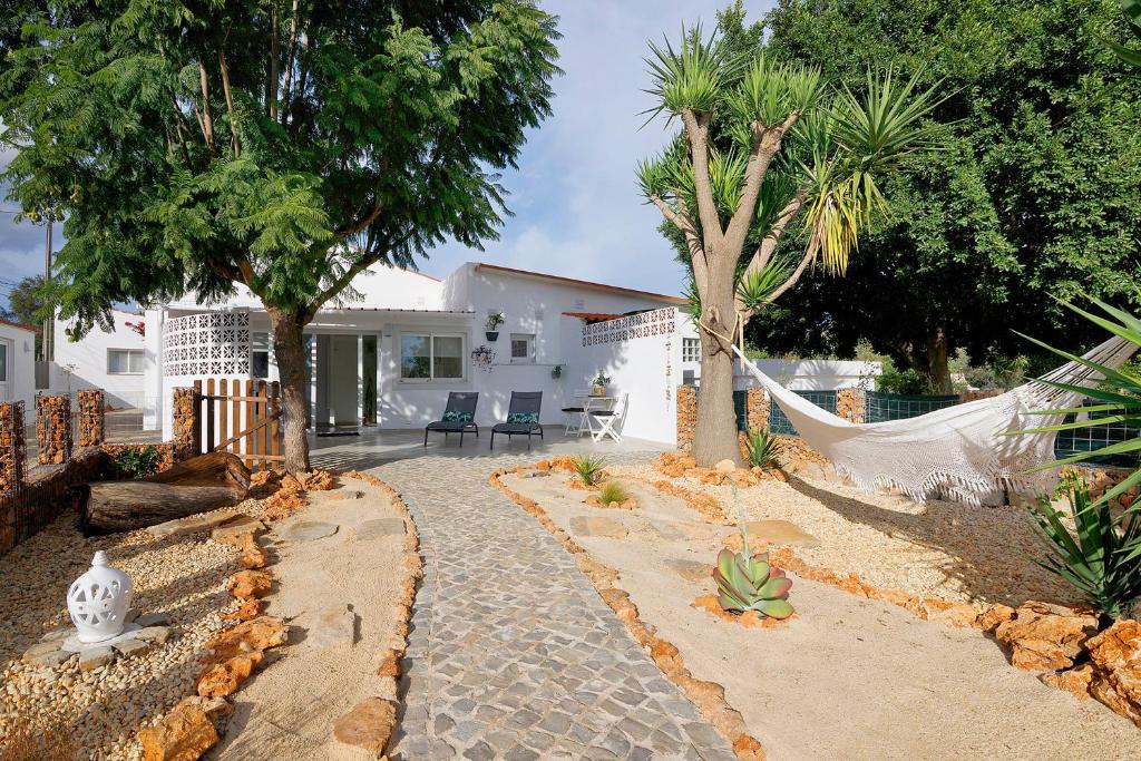 a house with a hammock in a yard with trees at Moncoração Village in Moncarapacho