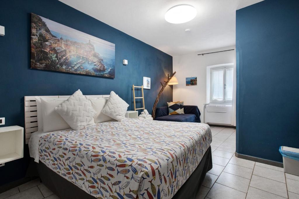 a bedroom with a bed and a blue wall at Ca Du Grifun 2 in Vernazza