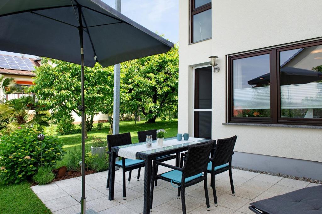 a table with chairs and an umbrella on a patio at Ferienwohnung mit Terrasse in Salem