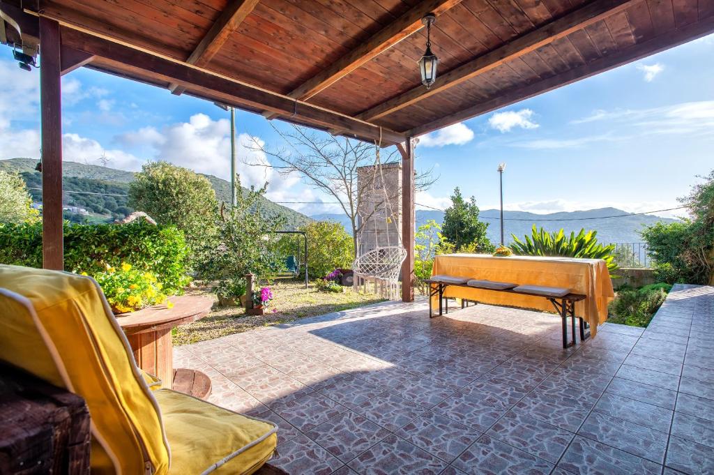 a patio with a bench and a view of the mountains at Casa Michela in Viddalba