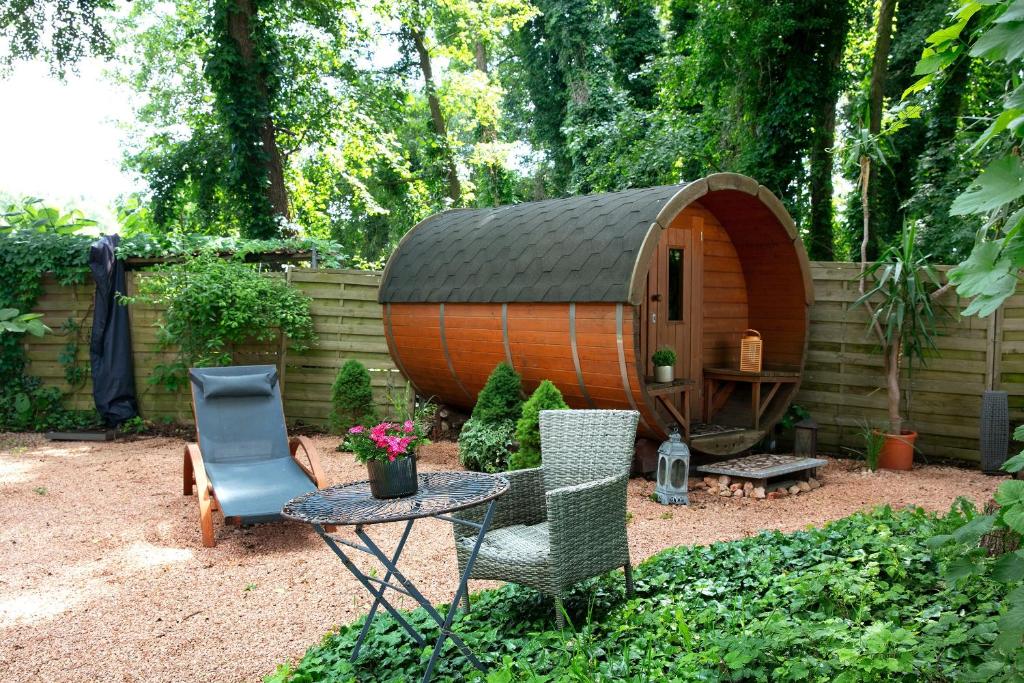 a small tree house in a garden with a table and chairs at Ferienhäuschen am See in Bestensee
