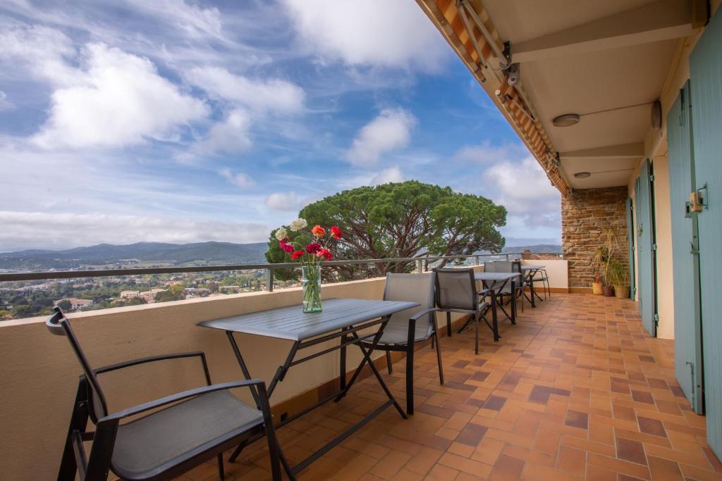 a balcony with tables and chairs and a tree at Le Mas Berliat studio N° 10 in Bormes-les-Mimosas