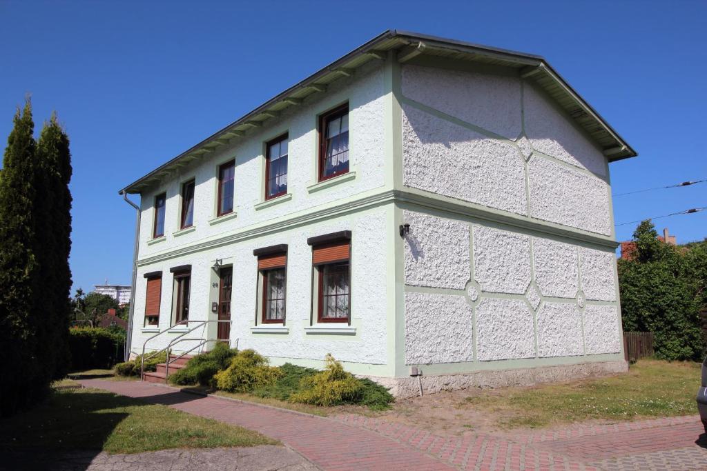 an old white building with windows on a street at Ferienwohnungen Vieth in Sassnitz