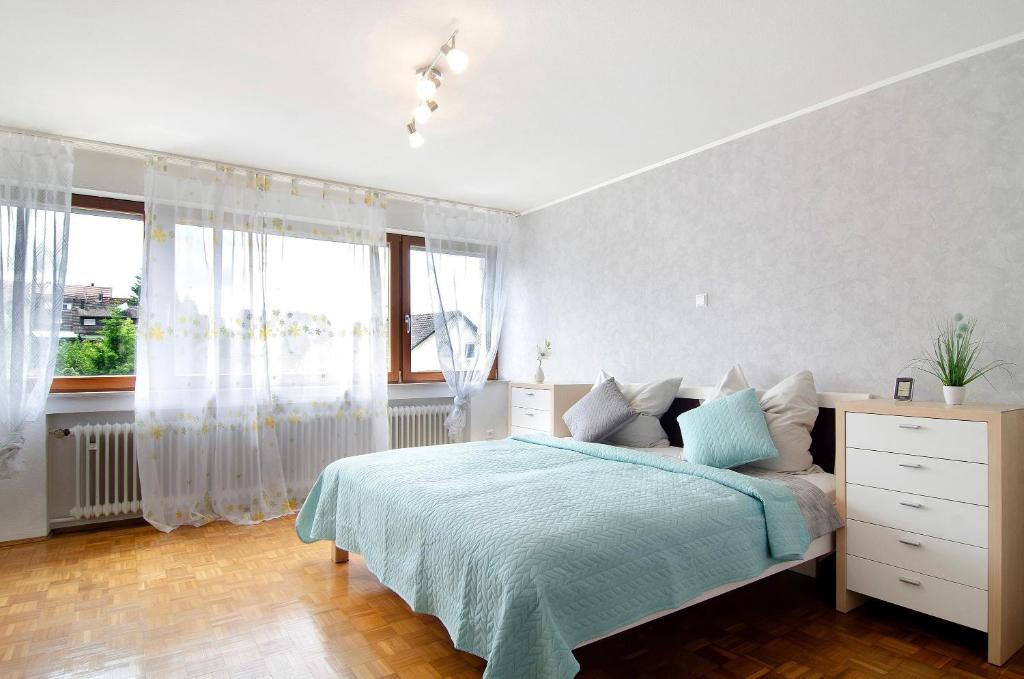 a white bedroom with a bed and a window at Ferienwohnung Marie in Niedereschach
