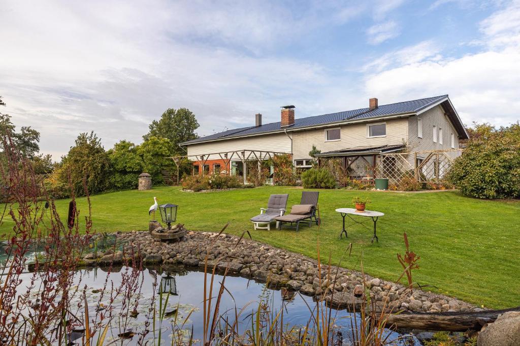 a large house with a pond in front of it at Ferienwohnungen Kämpenberg in Dingen