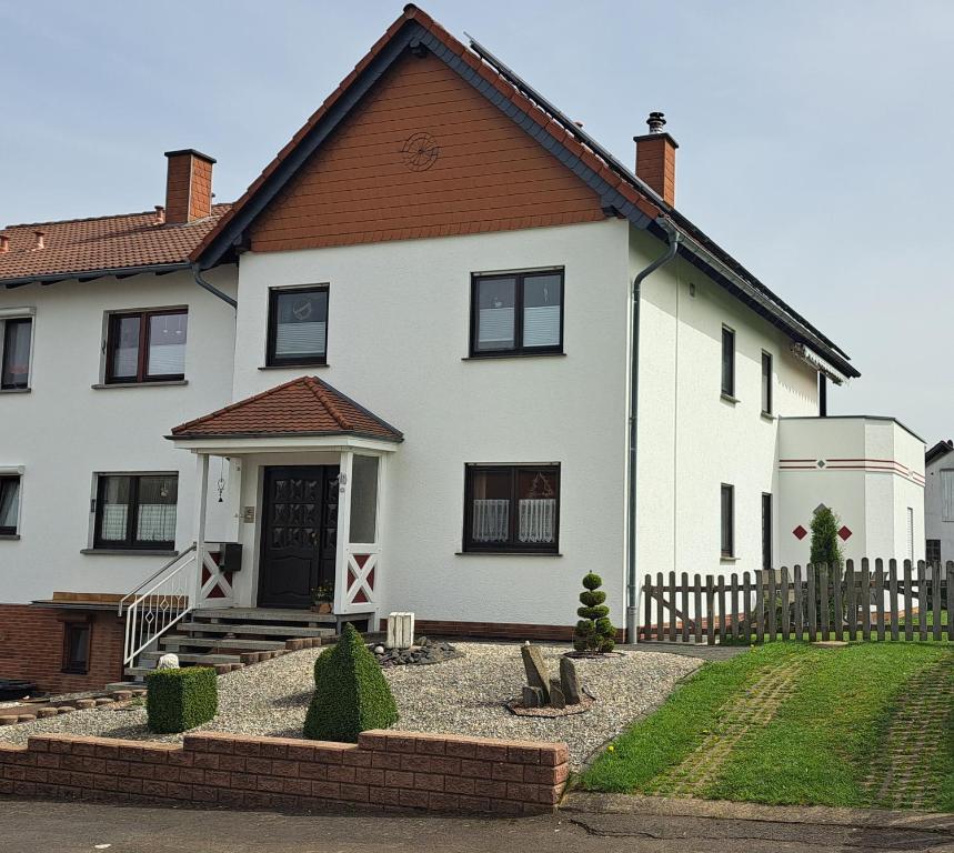 a white house with a brown roof at Pension Andrea in Herbstein