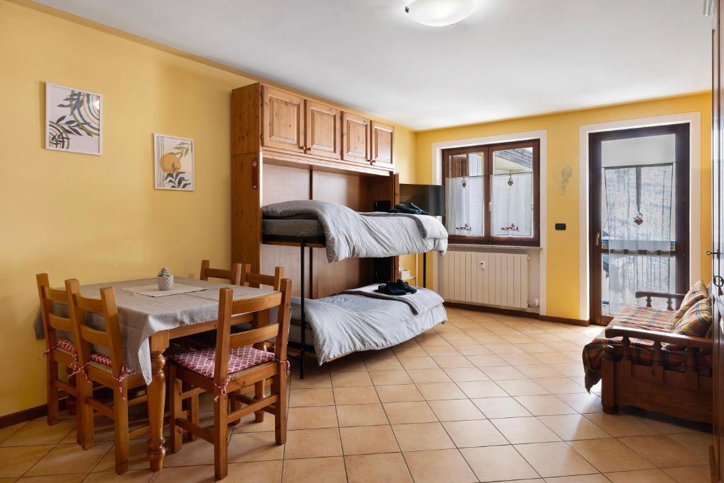 a living room with a table and a room with a bunk bed at Plain Soleil ski home in Prato Nevoso