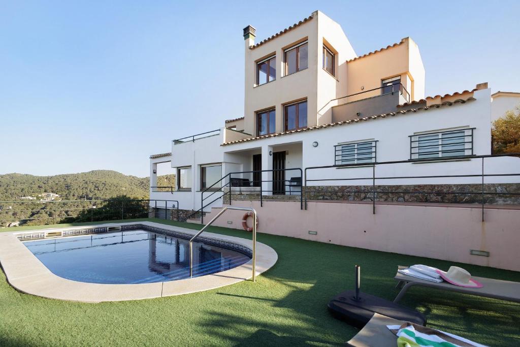 a house with a swimming pool in the yard at Racó 72 in Begur