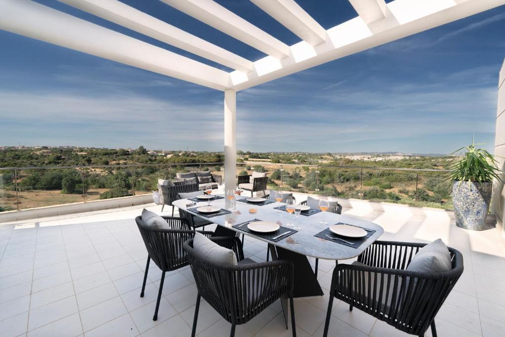 a dining room with a table and chairs on a balcony at Penthouse Monte da Eira - Sunset in Albufeira