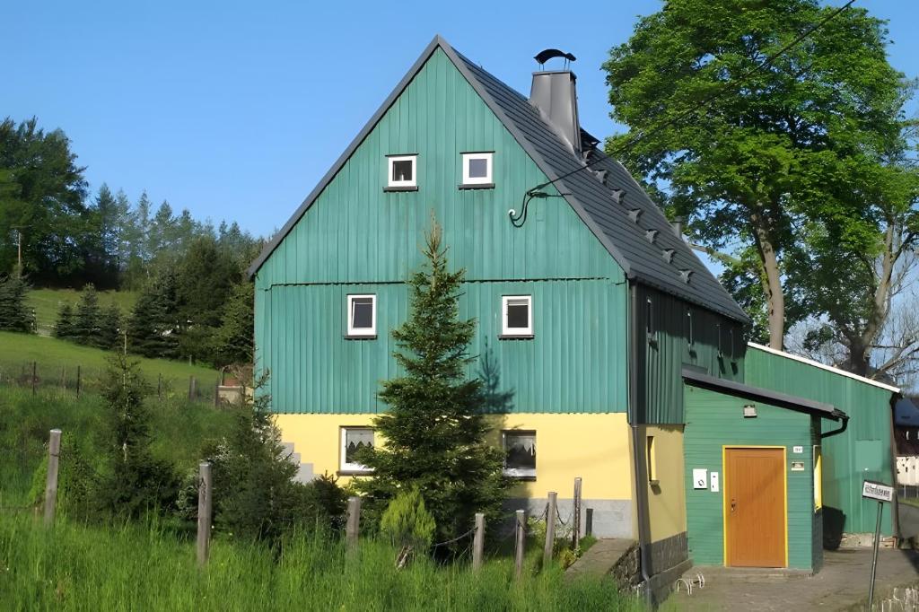 a green and yellow barn with a green roof at Grünes Ferienhaus in Nassau