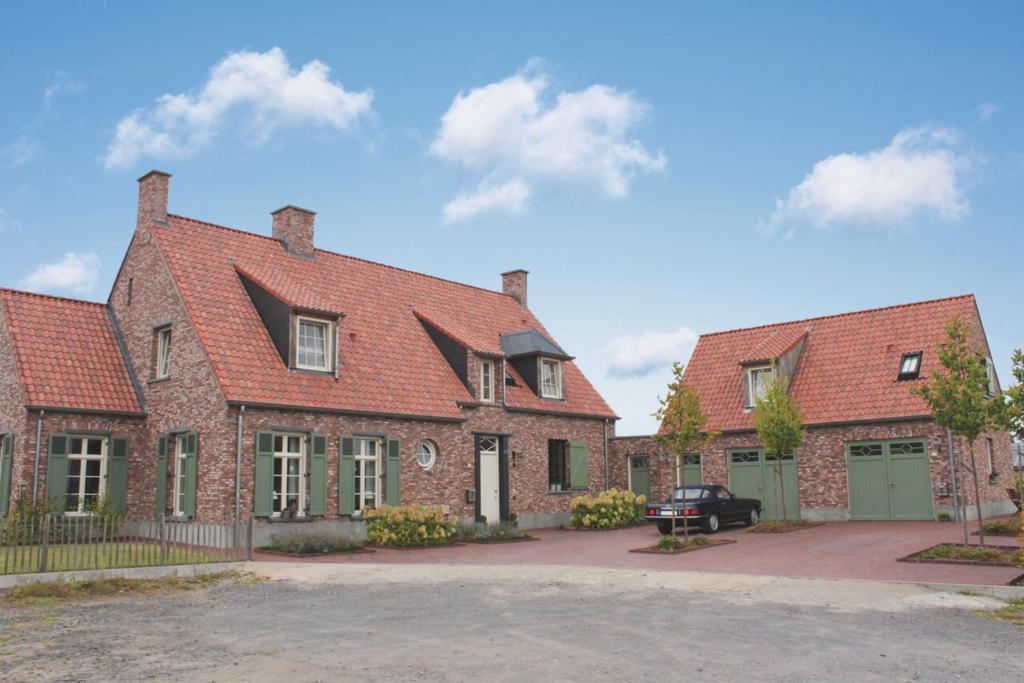 ein großes Backsteinhaus mit einem Auto davor geparkt in der Unterkunft Ferienwohnung Zur Remise in Stadtlohn