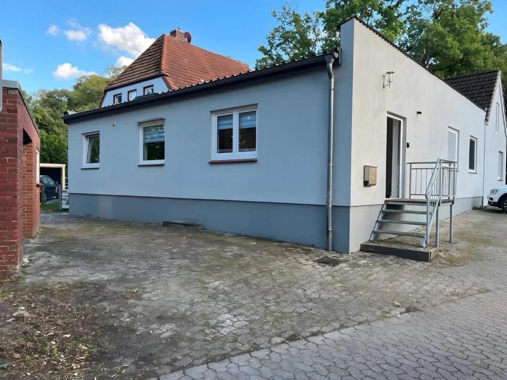 a white building with a staircase next to it at Zum Waldblick in Wulsbüttel