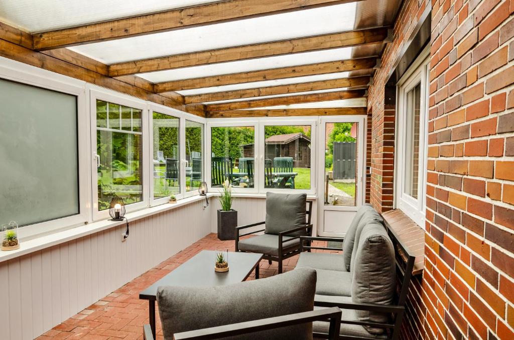 a screened porch with a brick wall and windows at Seehund in Stedesdorf