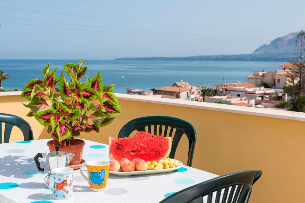 a table with a plate of fruit on a balcony at Casa Viola - a 100 metri dal mare in Trappeto