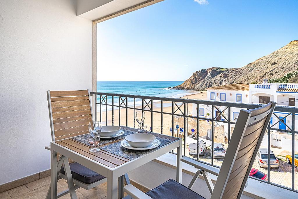 a table and chairs on a balcony with a view of the ocean at Beach Apt 1 In Burgau in Burgau