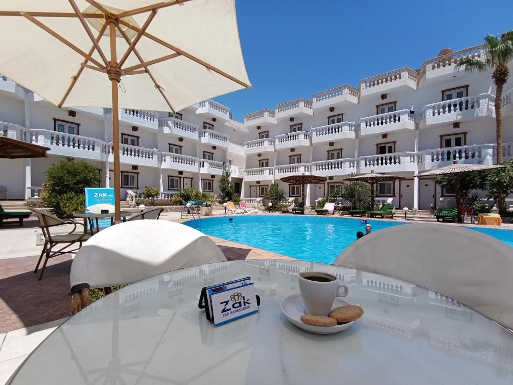 a table with a cup of coffee in front of a hotel at Zak Inn Residence in Hurghada