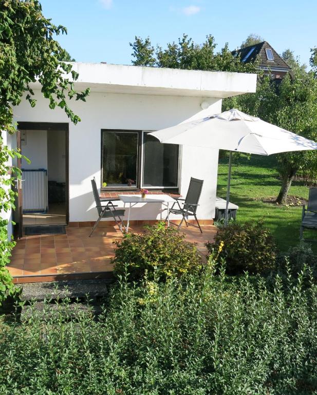 a patio with an umbrella and chairs and a table at Seeblick Ferienbungalow in Leezen