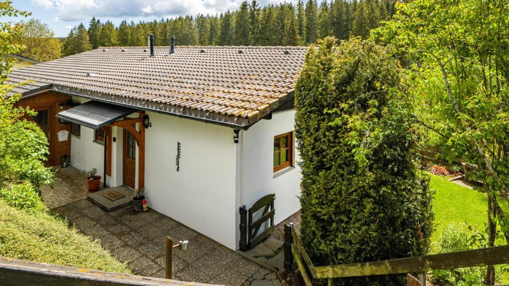 a small white house with a wooden roof at Schwarzwaldliebe in Lenzkirch