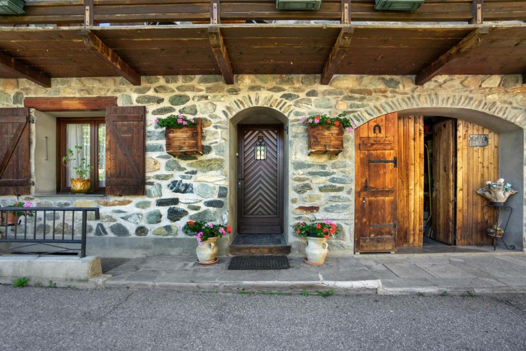 a stone house with a wooden door and two windows at Chalet Lou Murgis in Saint-Sorlin-dʼArves