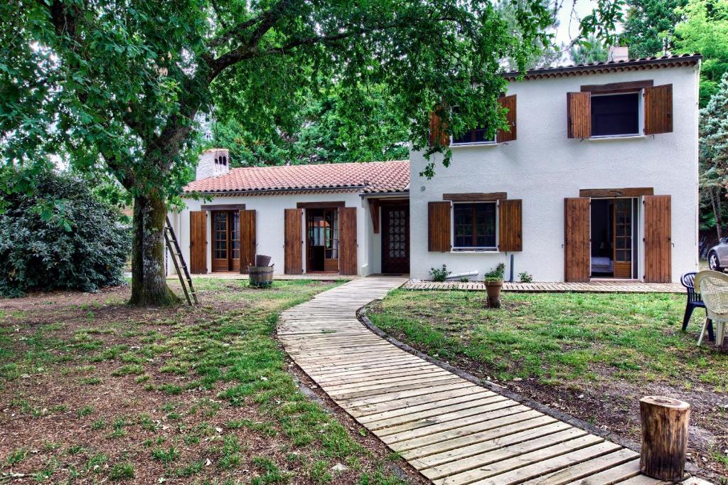 a house with a wooden walkway in front of it at Villa Rodolphe in Le Pian-Médoc
