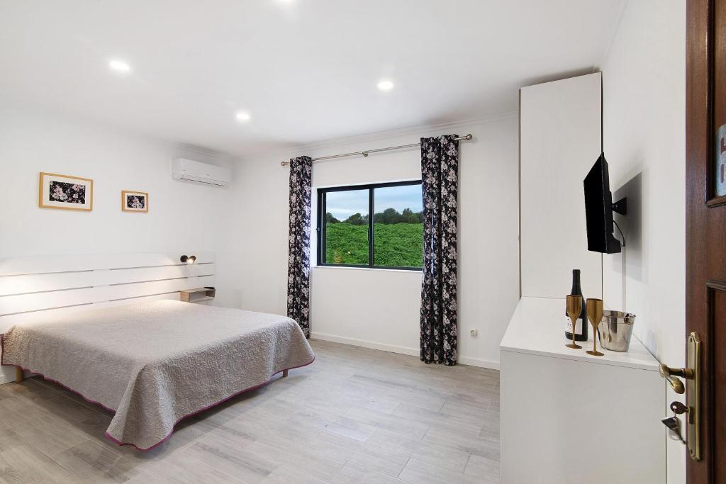 a white bedroom with a bed and a window at Apartamento Nº6 - Sunset in Olhão