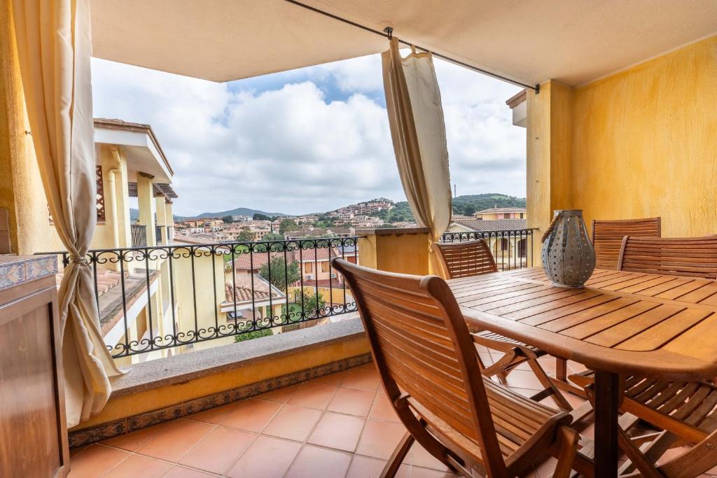 ein Balkon mit einem Holztisch und Stühlen in der Unterkunft Casa Sami in Villasimius