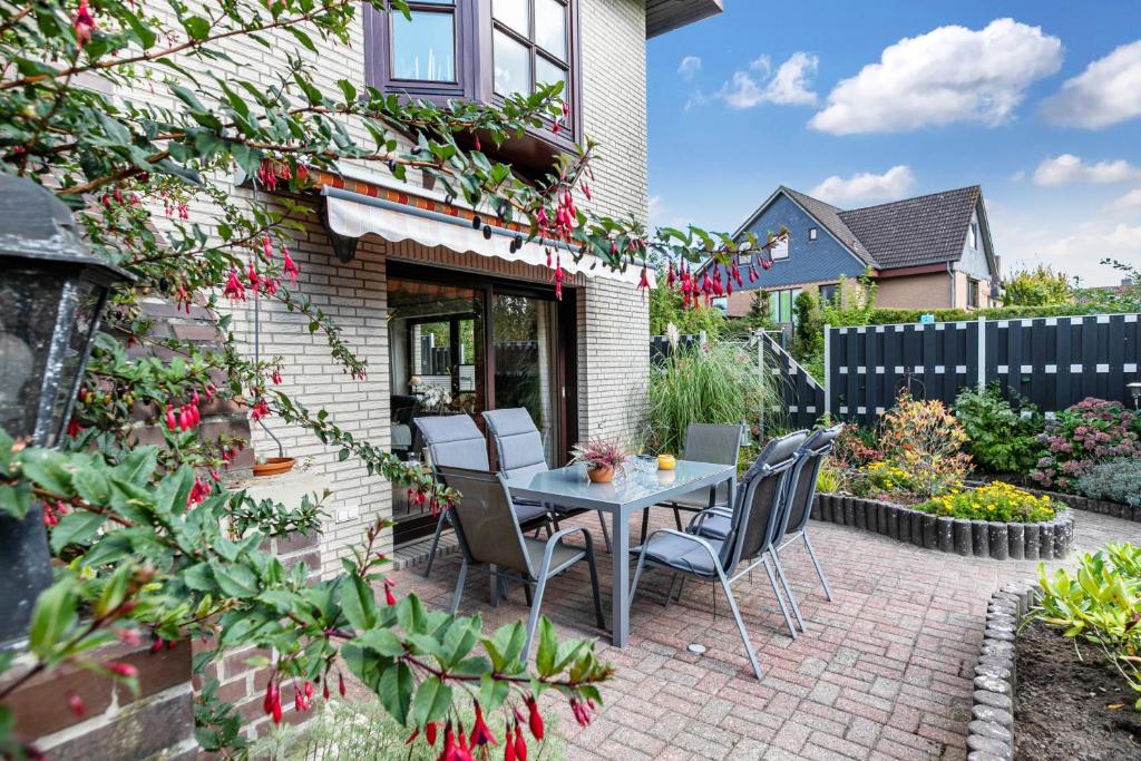a patio with a table and chairs in a garden at Ferienwohnung Hennings in Bargenstedt