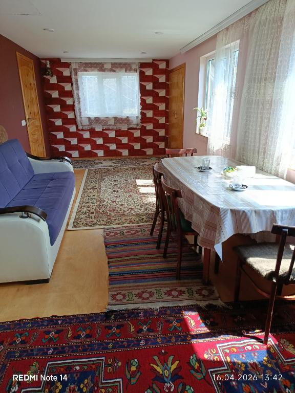 a living room with a table and chairs and a rug at Qusar Eniğ kend in Qusar