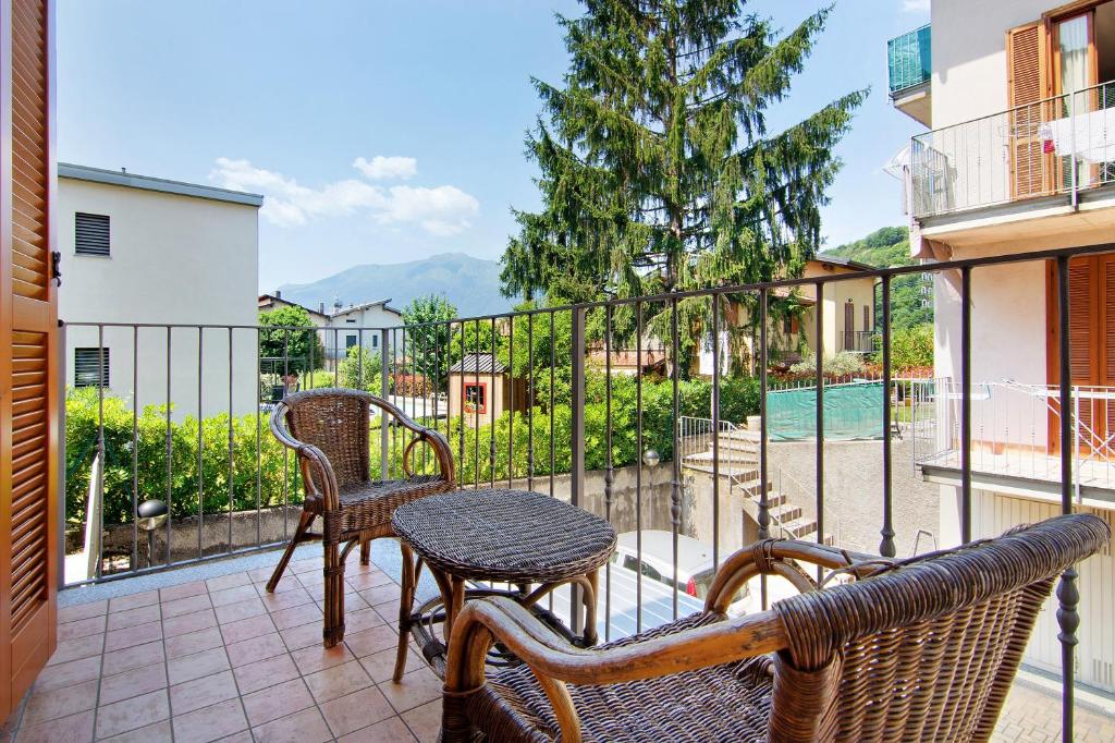 a balcony with a table and chairs on a balcony at Colorful Apartment in Colico