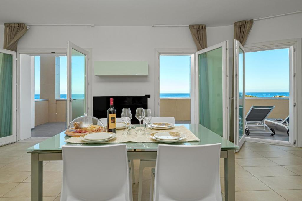 a dining room with a table with wine bottles and glasses at Villa Marconi Apartment 9 in Golfo Aranci