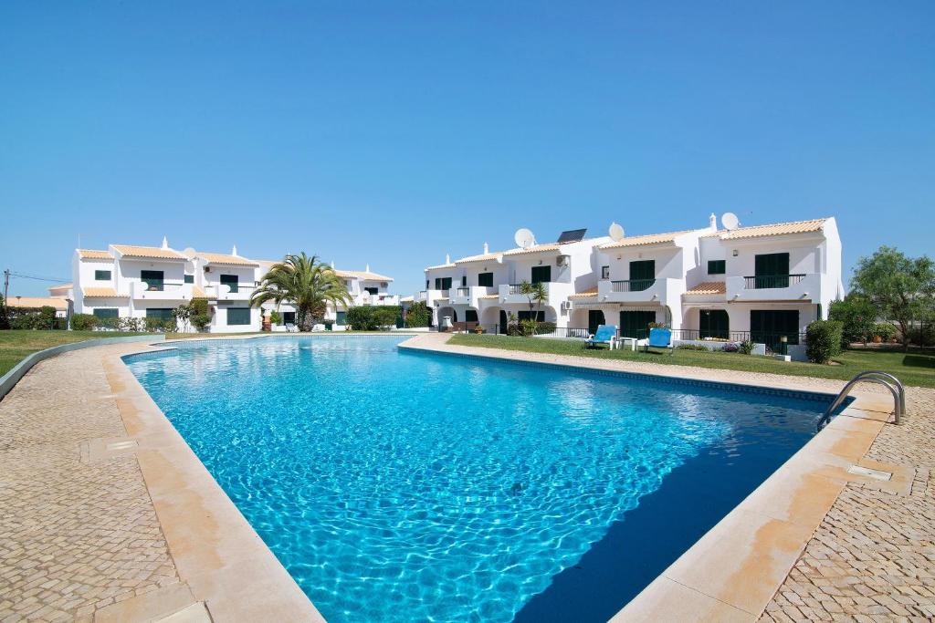 a swimming pool in front of some houses at Villa Janeca in Albufeira